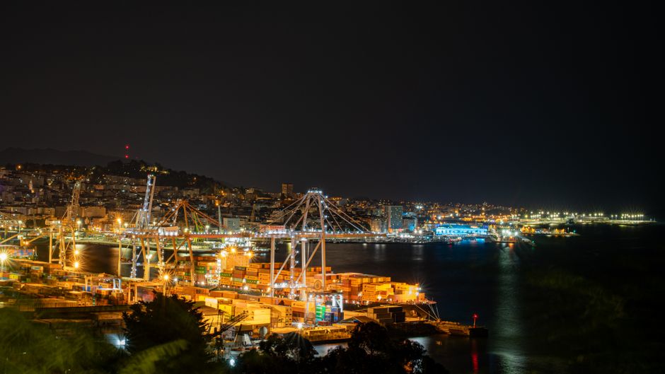 El puerto de Vigo iluminado de noche, con la ciudad detrás