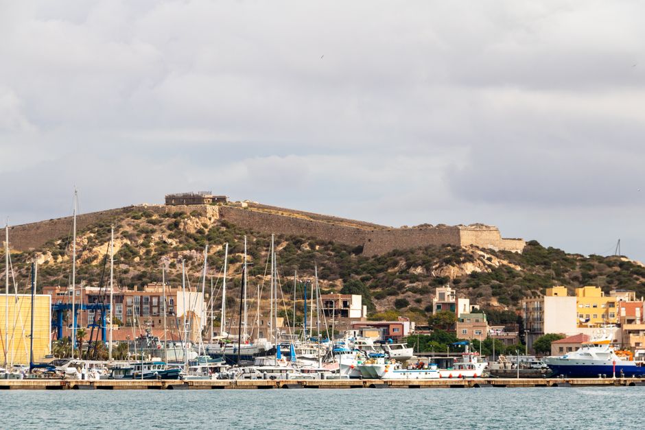 El puerto de Cartagena con sus veleros y la fortaleza sobre el cerro
