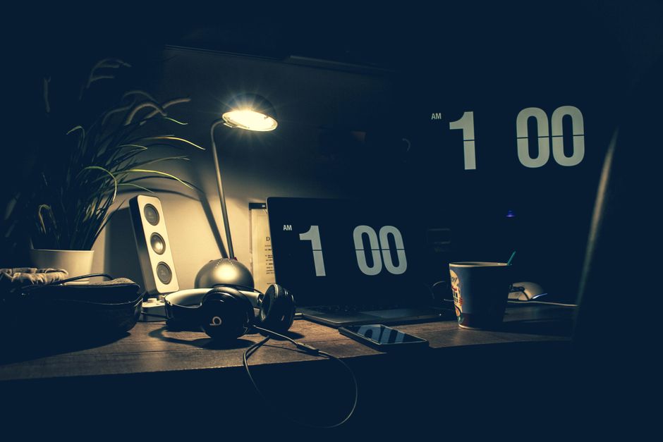 Escritorio a oscuras con la pantalla marcando la una de la madrugada, imagen del chat de parejas online