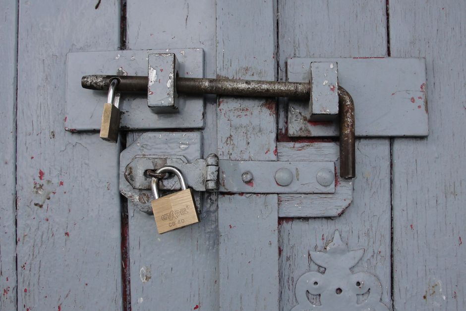 Candados de latón cerrando una puerta de madera, imagen del registro de collares