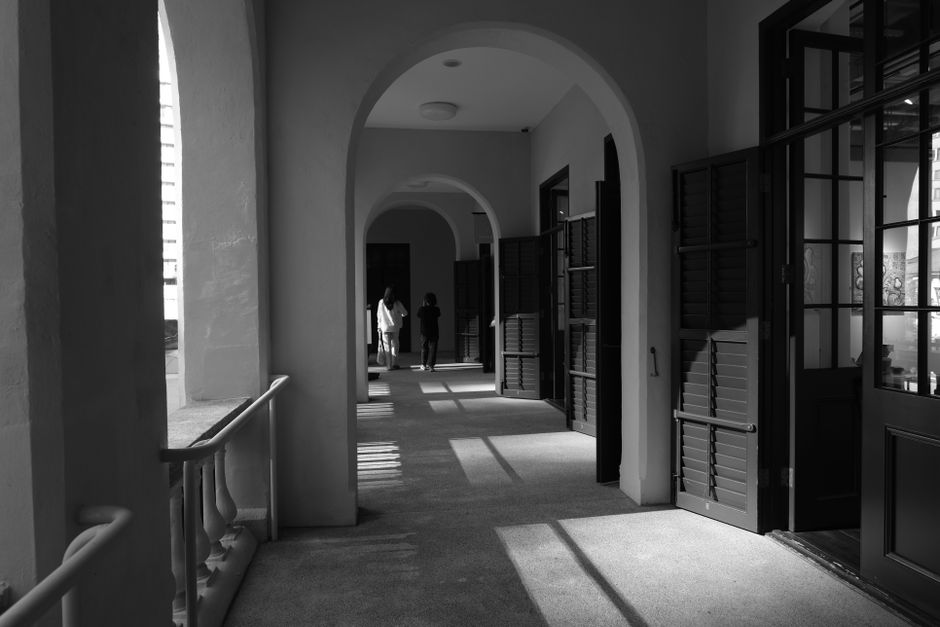 Corredor de arcos en blanco y negro, con puertas abiertas a los dos lados