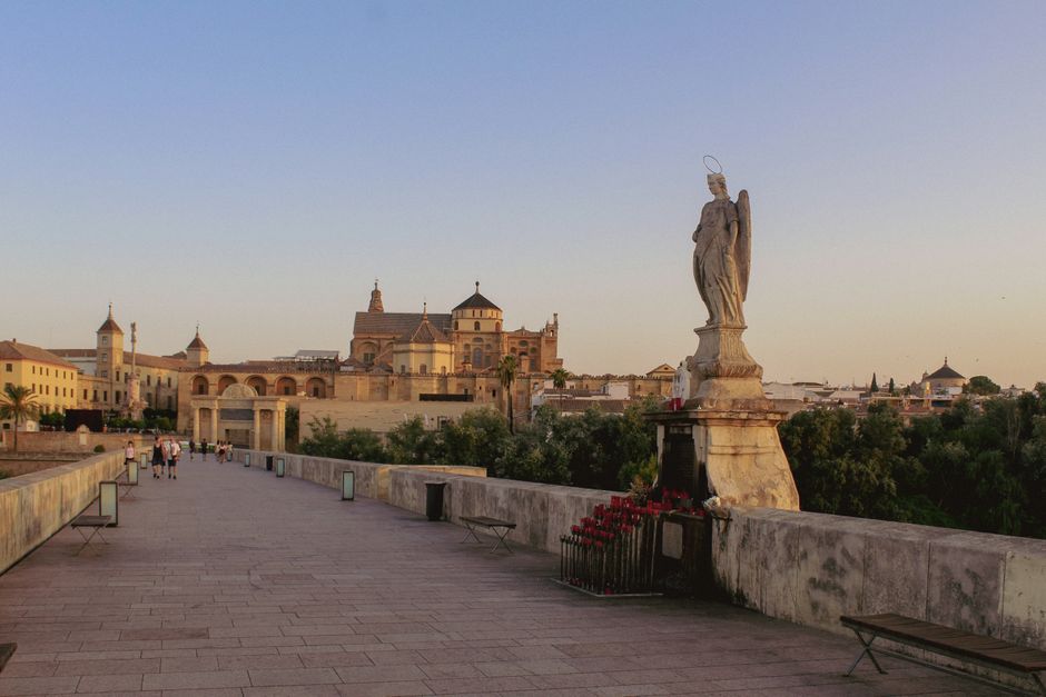 Chat BDSM de Córdoba: El puente romano de Córdoba al atardecer, con la ciudad histórica detrás