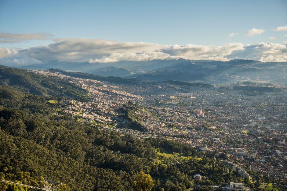 Colombia: Aerial shot of Bogotá, Colombia, showcasing cityscape and surrounding lush mountains.